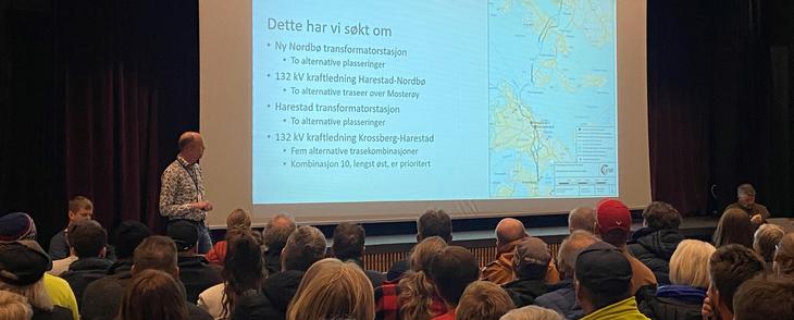 Stort lerret viser presentasjon av konsesjonssøknad under folkemøte på Rennesøy i 2022