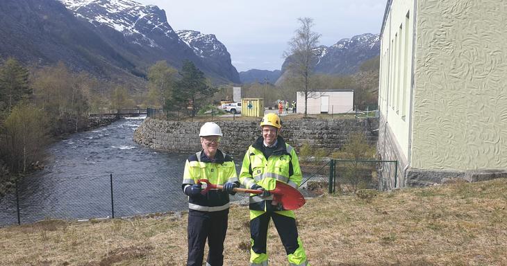 Ordfører Frode Fjeldsbø i Gjesdal kommune holder i spaden sammen med administrerende direktør Bjørn Honningsvåg i Lyse Kraft DA foran eksisterende kraftverk i Maudal. 